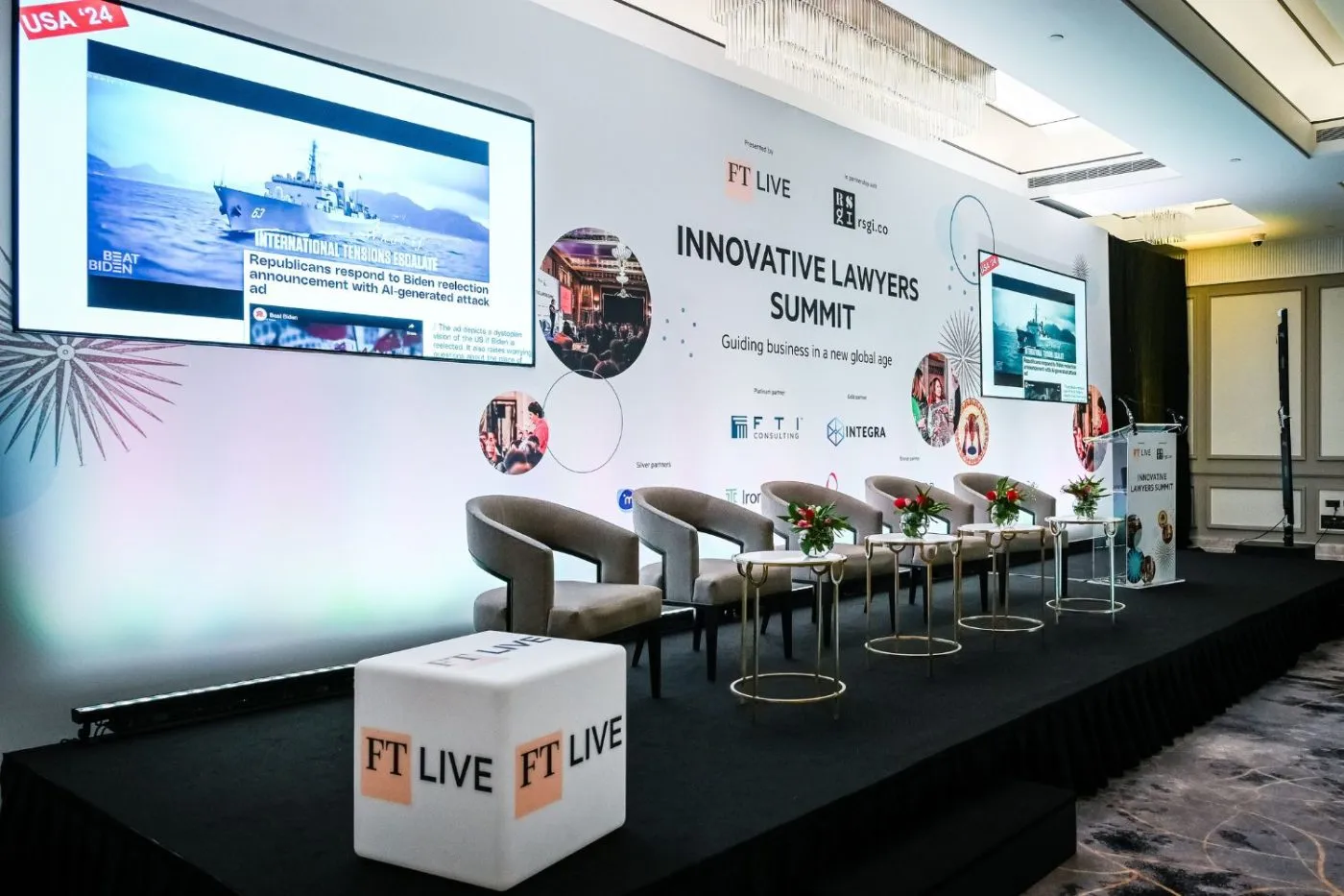 Stage backdrop with integrated LED screens, branded lectern, and light cube