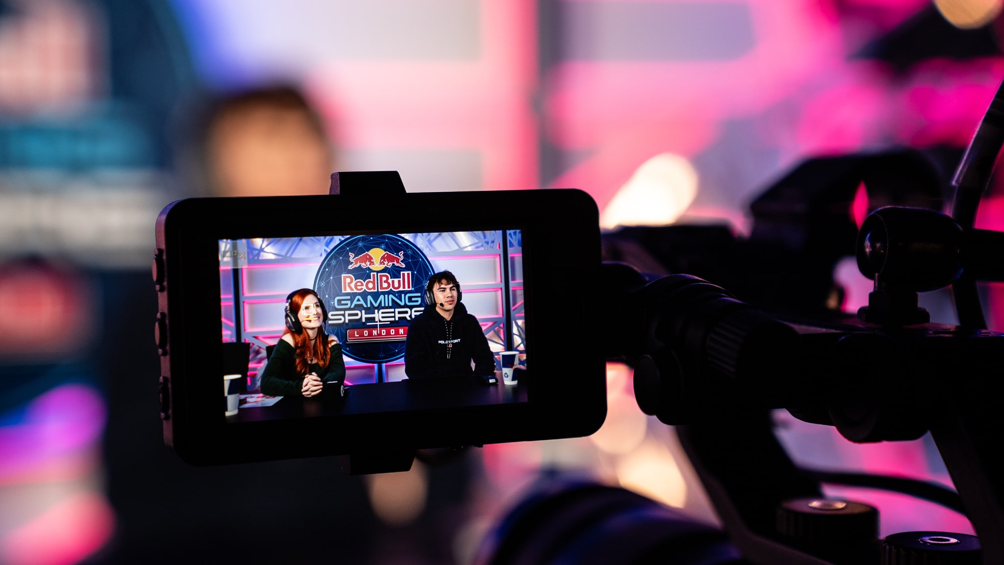 Engaging live stream image with Animus Group for a gaming tournament. Two presenters are hosting the tournament at the red bull gaming sphere, surrounded by red and blue lighting