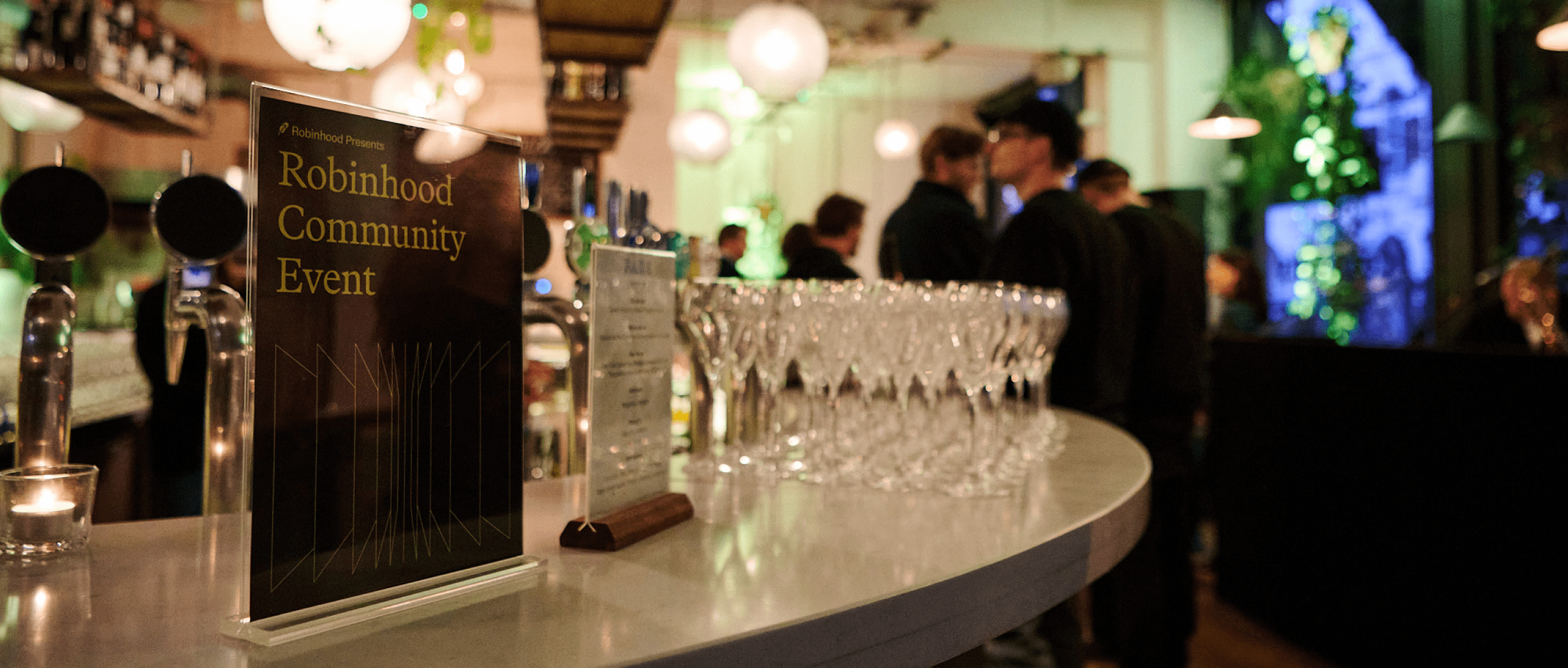 Interior shot of the event branding launch event for Robinhood, a branded agenda menu sits ontop of the bar in the venue